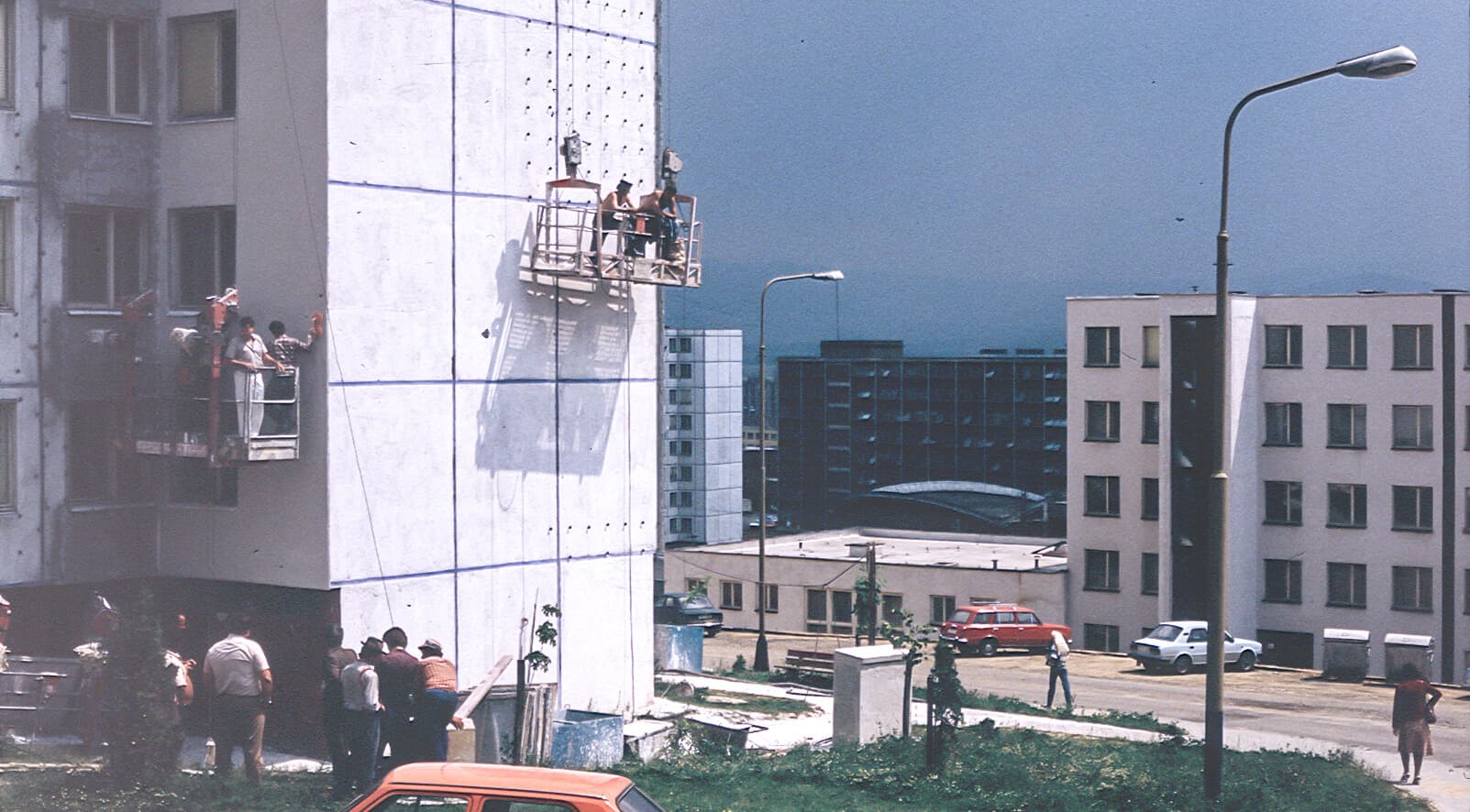Rokamat Historie — Handwerker auf Hebebühne an einer Fassade in den 1980er-Jahren